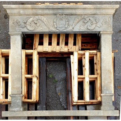 Light limestone fireplace with scrolls and coat of arms